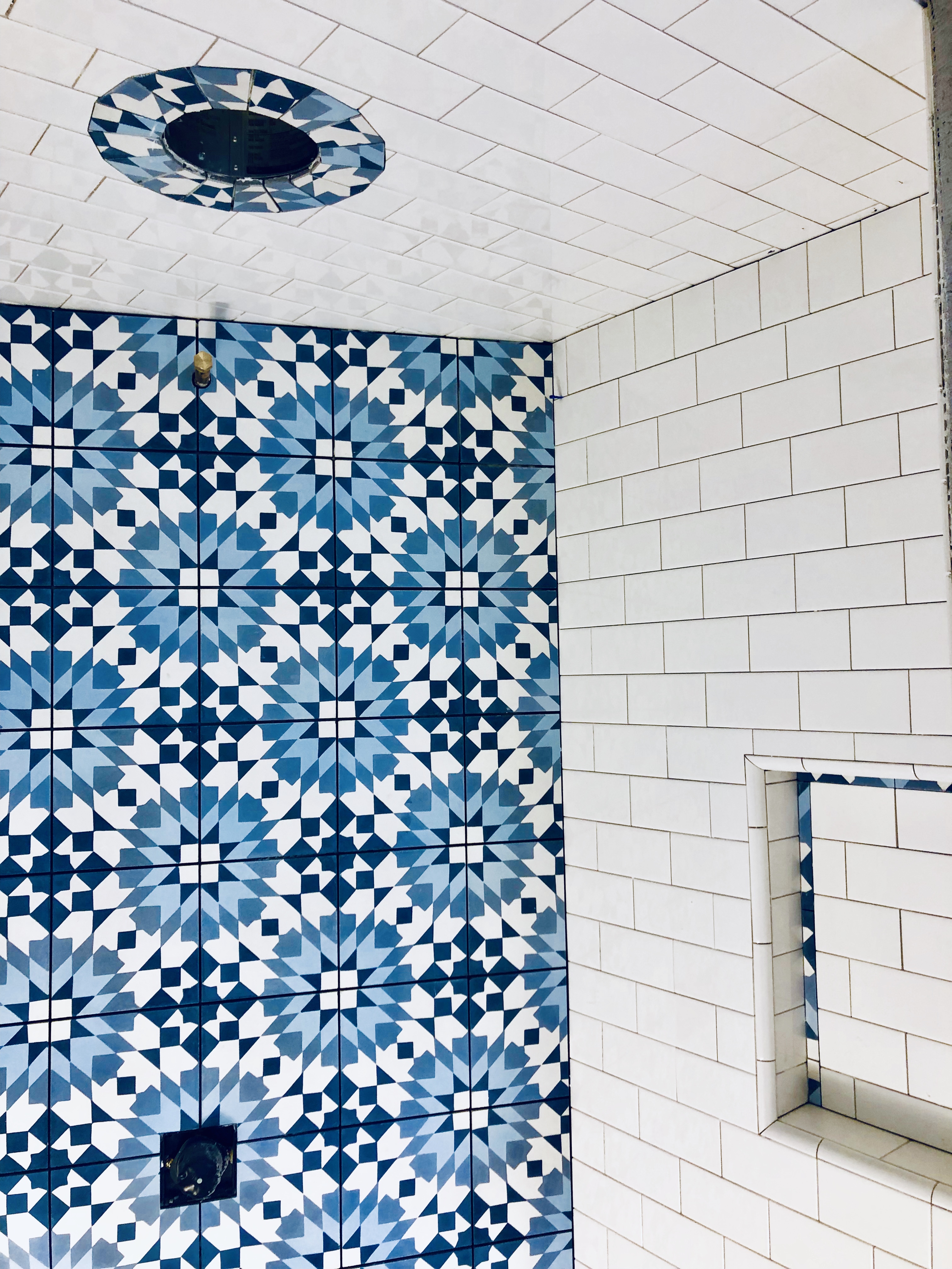 This shower featured blue encaustic tile with 3”x 6” subway tile.