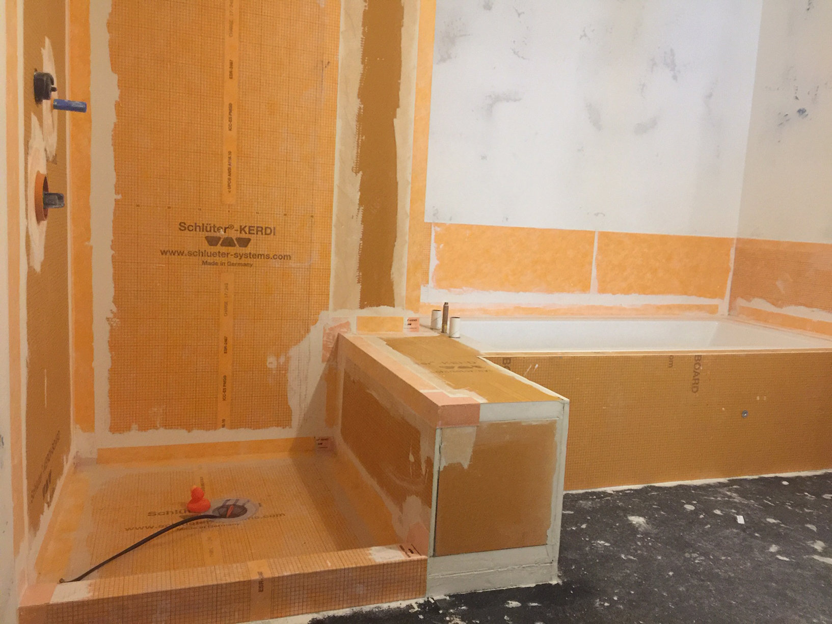 Waterproofing membrane was wrapped from the wall to the tub deck to create a waterproof splash zone for the tub area.
