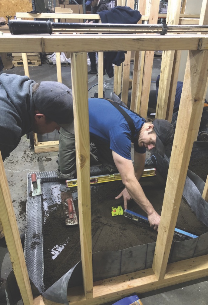 Apprentices learning how to create a proper pitch to the drain.